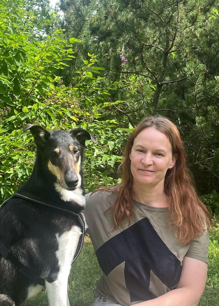 Eläinlääkäri Aija Makkonen koiransa kanssa metsässä